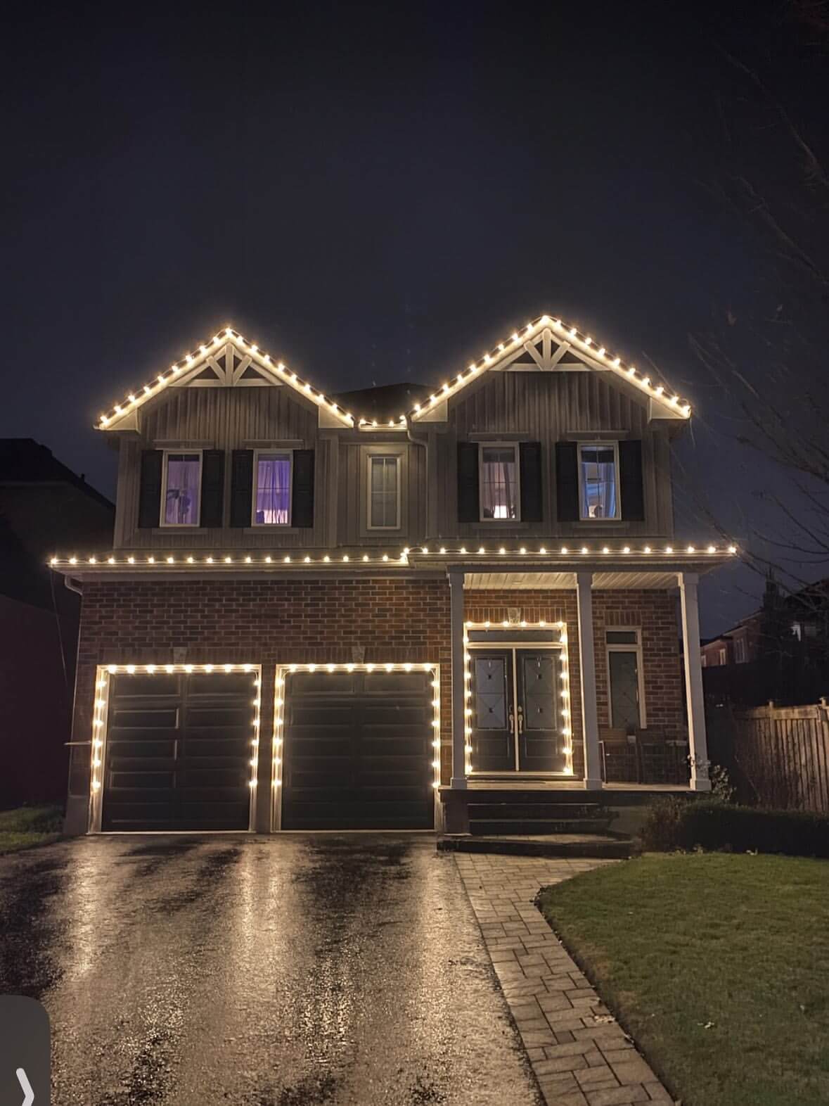 Warm white C9 Christmas light installation on a two-storey home with full roofline and garage in Durham Region